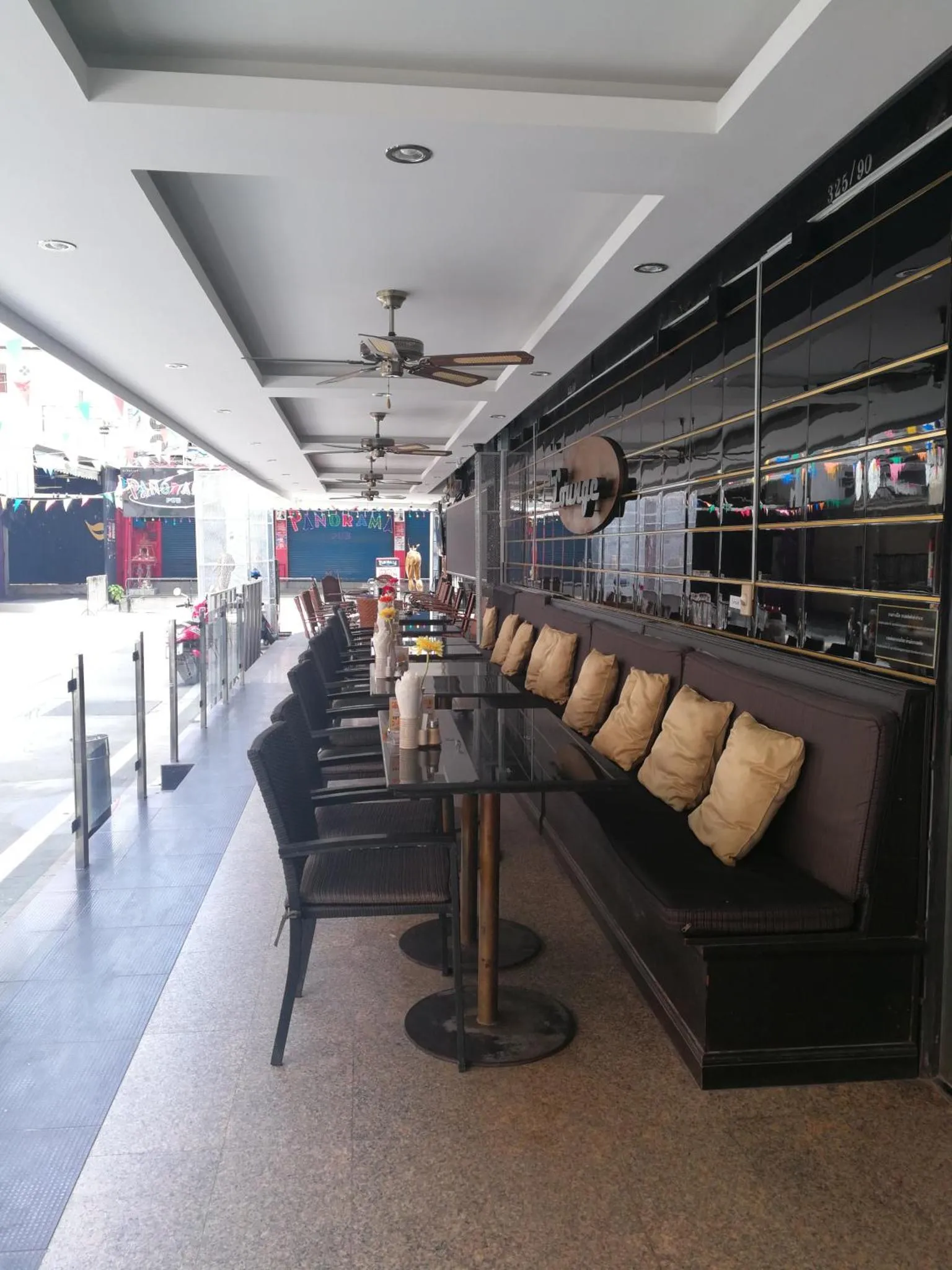 Terrasse ombragée avec tables et assises confortables.