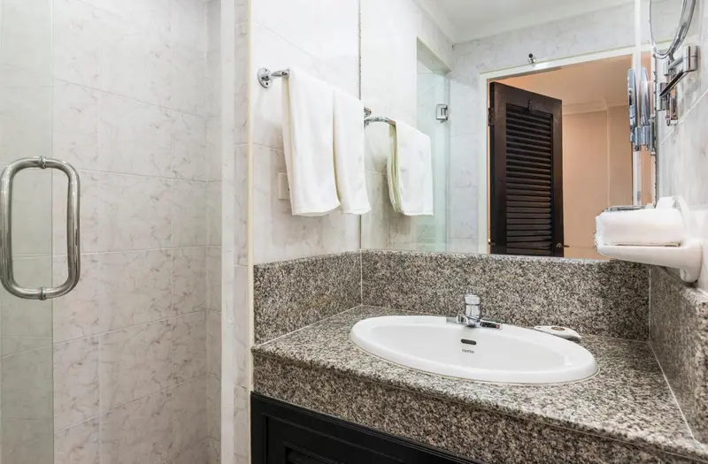 Une salle de bain lumineuse avec un lavabo et des serviettes.