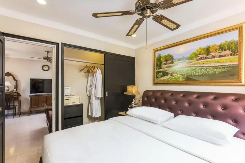 Une chambre avec un grand lit et un tableau décoratif.