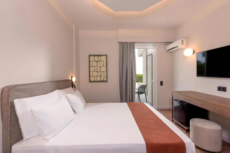 Une chambre lumineuse avec un grand lit et un accès à une terrasse.