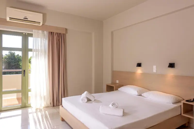Une chambre lumineuse avec un grand lit et un accès à une terrasse.