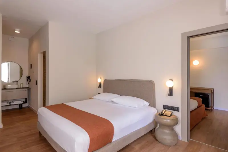 Une chambre lumineuse avec un grand lit et un espace détente.