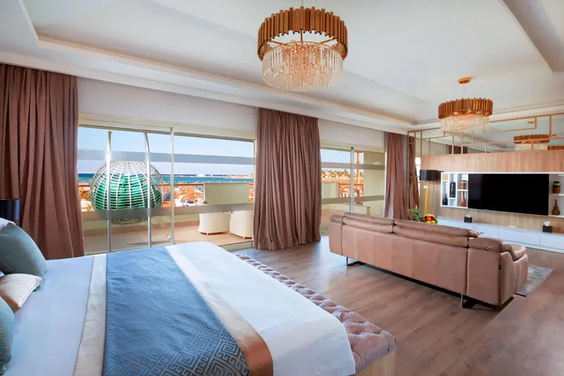 Une chambre spacieuse avec un grand lit et un coin salon confortable.