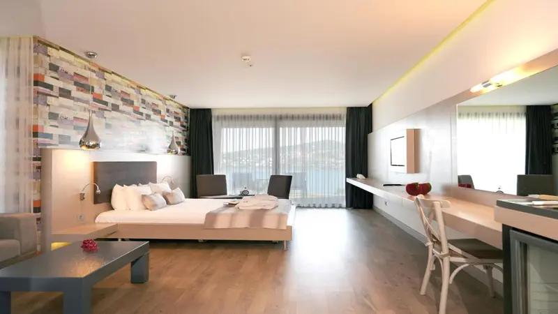 Une chambre lumineuse avec un grand lit et un bureau.