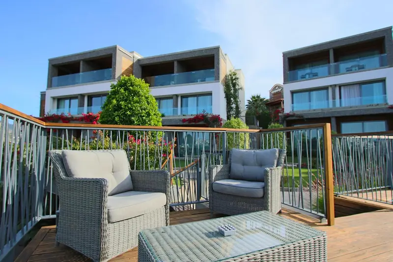 Terrasse aménagée avec mobilier de jardin et vue sur un bâtiment.