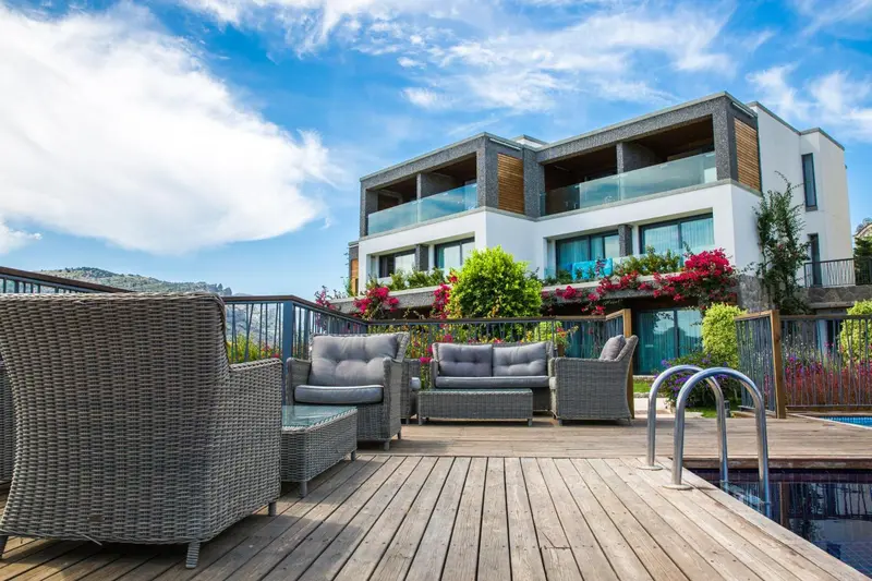 Terrasse aménagée avec mobilier de jardin et piscine devant un bâtiment moderne.