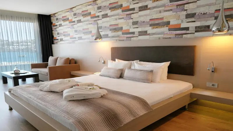 Une chambre lumineuse avec un grand lit et un coin salon.