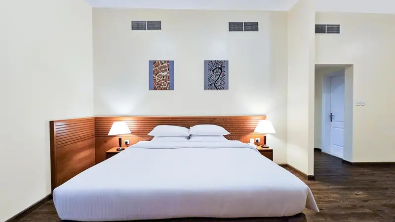 Une chambre d'hôtel avec un grand lit blanc et des tables de chevet.