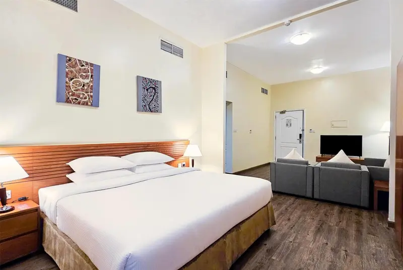 Une chambre lumineuse avec un grand lit et un coin salon.