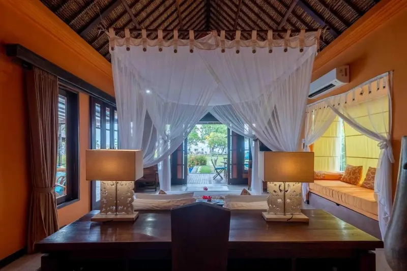 Une chambre lumineuse avec un lit à baldaquin donnant sur une vue extérieure.