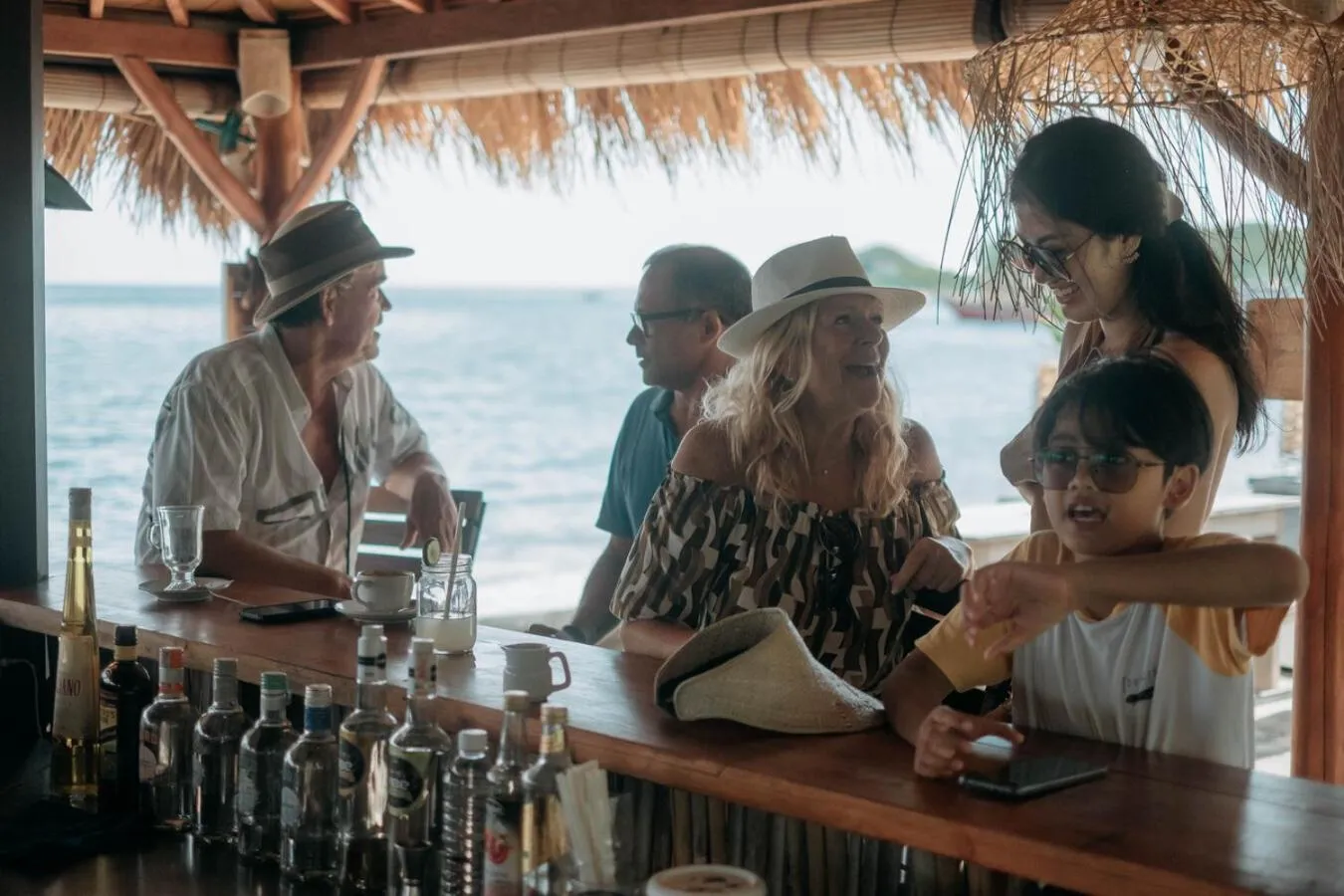 Des clients sont servis au comptoir d'un bar en bord de mer.