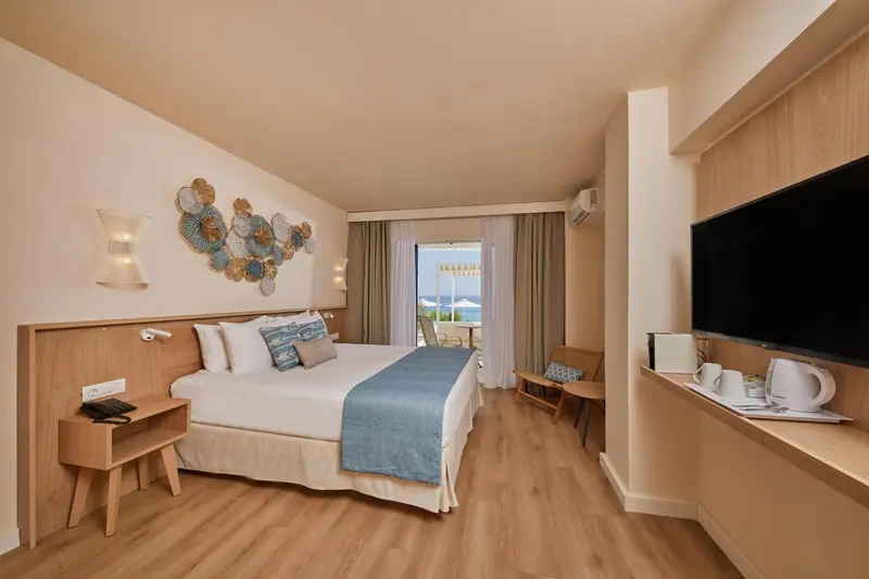 Une chambre lumineuse avec un grand lit et un coin salon.