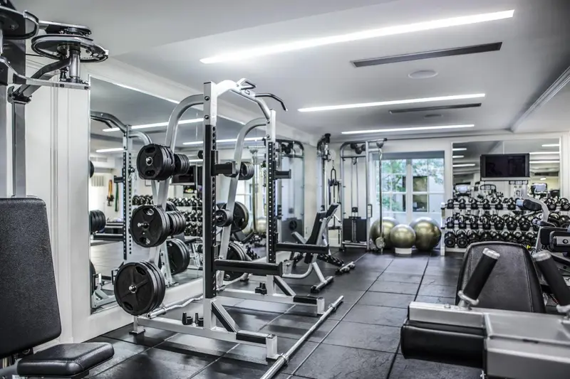 Une salle de sport moderne avec des équipements de musculation et des miroirs.