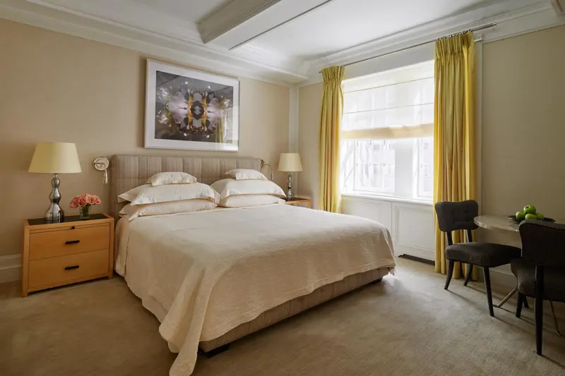 Une chambre lumineuse avec un grand lit et un coin bureau.