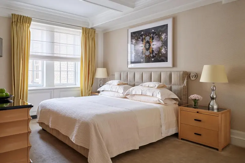 Une chambre lumineuse avec un grand lit recouvert d'une courtepointe blanche.