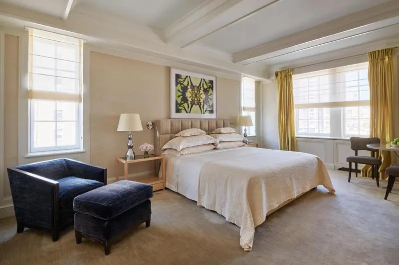 Une chambre lumineuse avec un grand lit et un coin salon.
