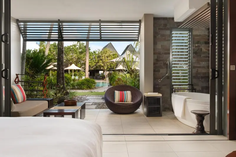Espace de détente extérieur avec mobilier et végétation luxuriante.