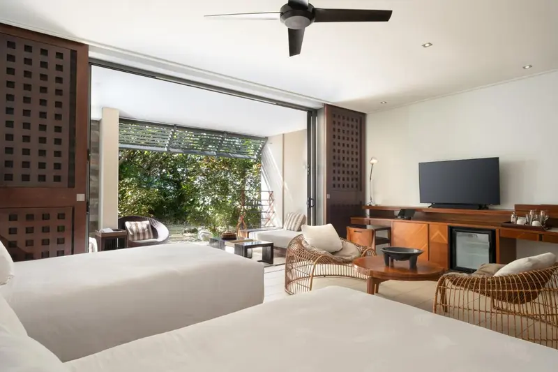 Une chambre lumineuse avec un lit double et un espace salon.