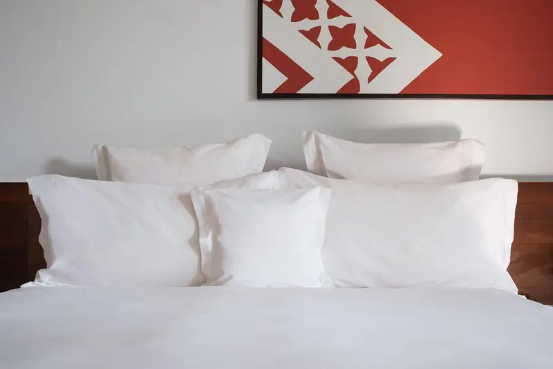 Un lit blanc avec des oreillers moelleux dans une chambre lumineuse.
