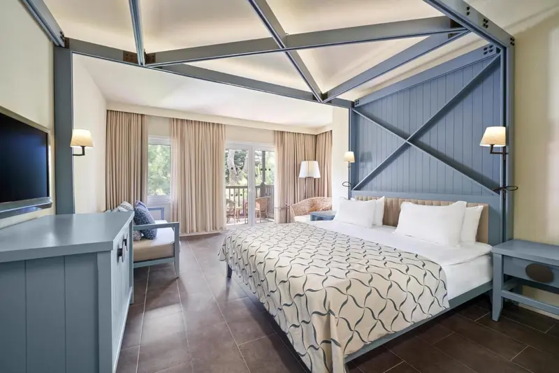 Une chambre lumineuse avec un grand lit et un accès à un balcon.