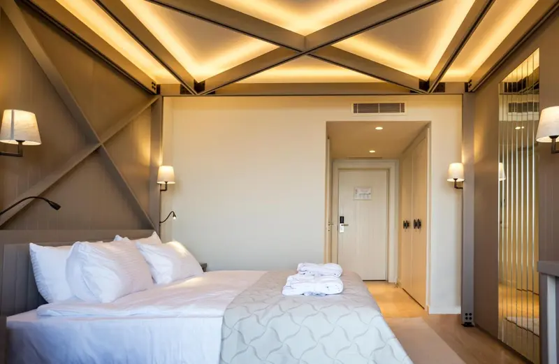 Une chambre lumineuse avec un grand lit et des lampes murales.