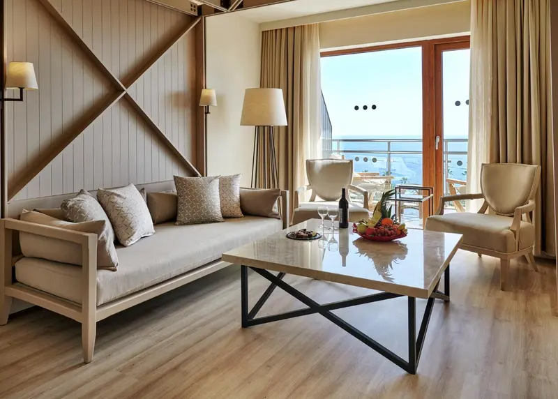 Un salon clair avec canapé, fauteuils et table basse.