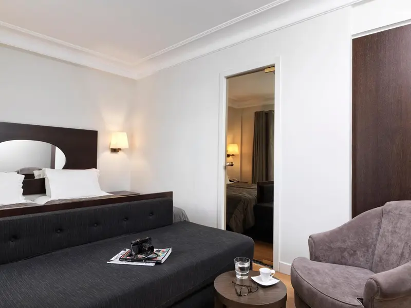 Une chambre avec un lit et un fauteuil.
