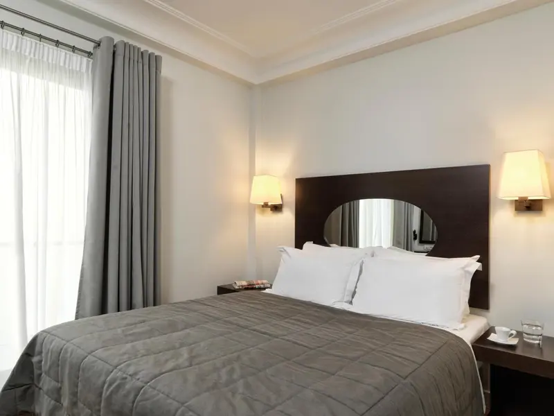 Une chambre lumineuse avec un grand lit et des lampes de chevet.