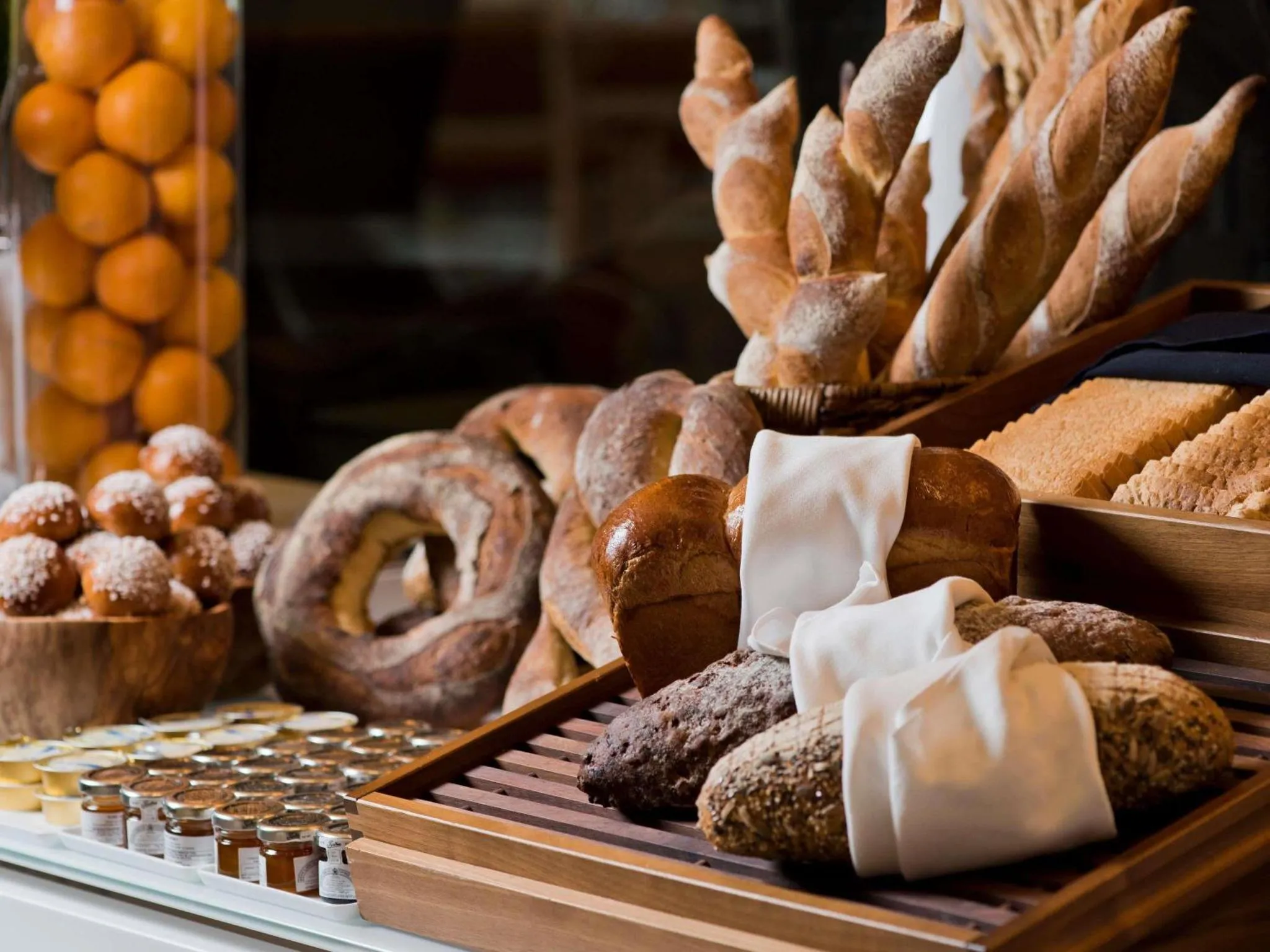 Présentation de viennoiseries et de pains variés sur un buffet.