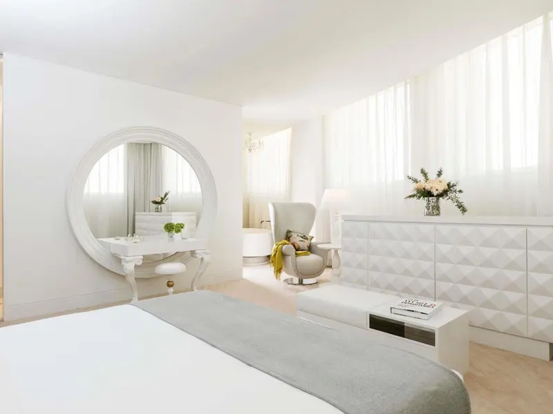 Une chambre lumineuse avec un lit et un espace coiffure.