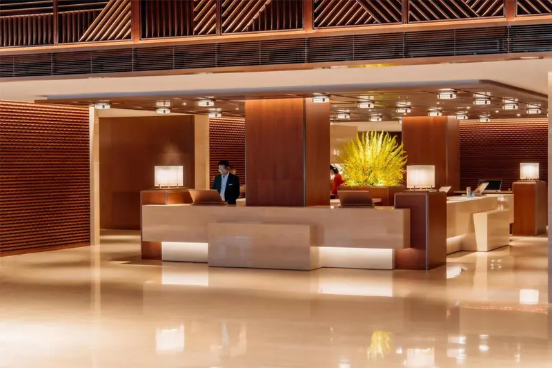Un comptoir d'accueil moderne dans un hall d'hôtel éclairé.