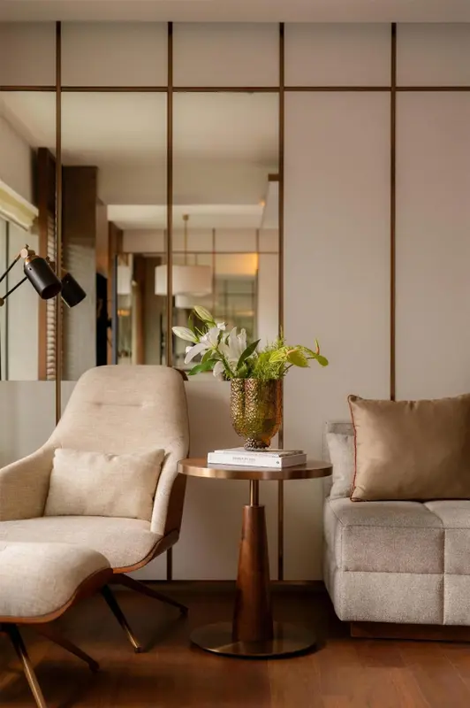 Un fauteuil et un canapé confortables se trouvent dans un espace intérieur lumineux.
