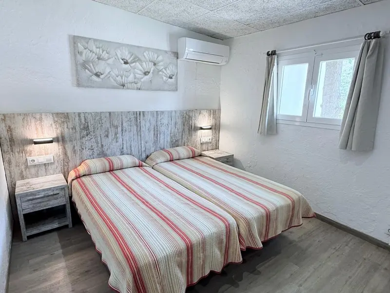 Une chambre lumineuse avec un grand lit et des tables de chevet.
