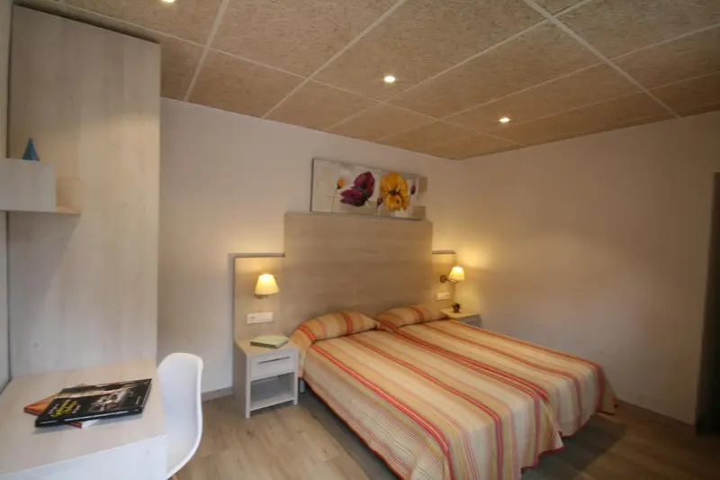 Une chambre lumineuse avec un lit double et une décoration florale.