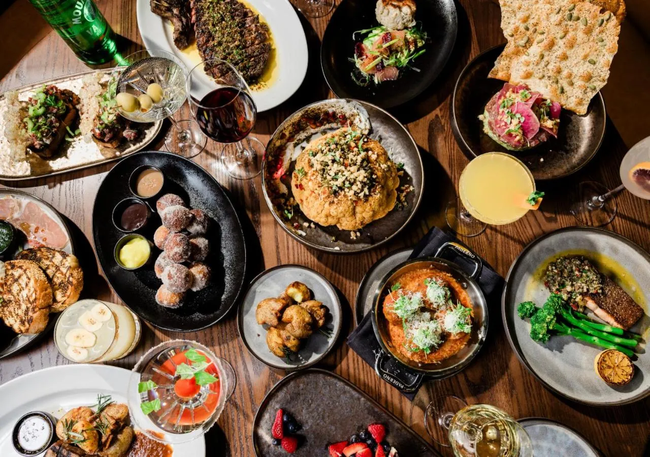 Une table généreusement garnie de divers plats et boissons.