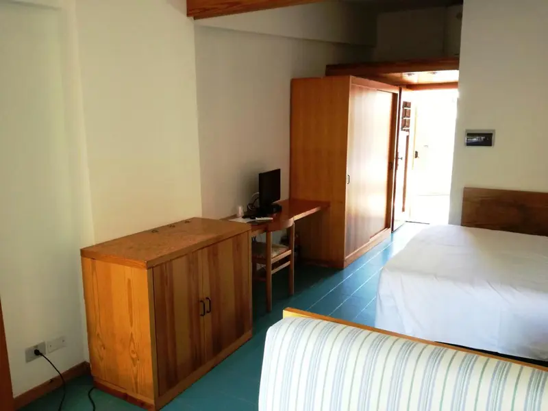 Une chambre lumineuse avec un lit et un bureau en bois.