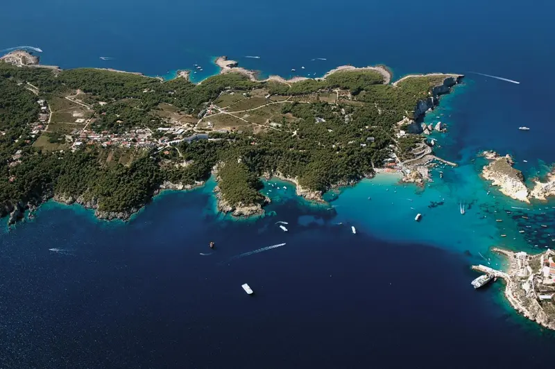 Vue aérienne d'une côte rocheuse avec une eau turquoise et des embarcations.