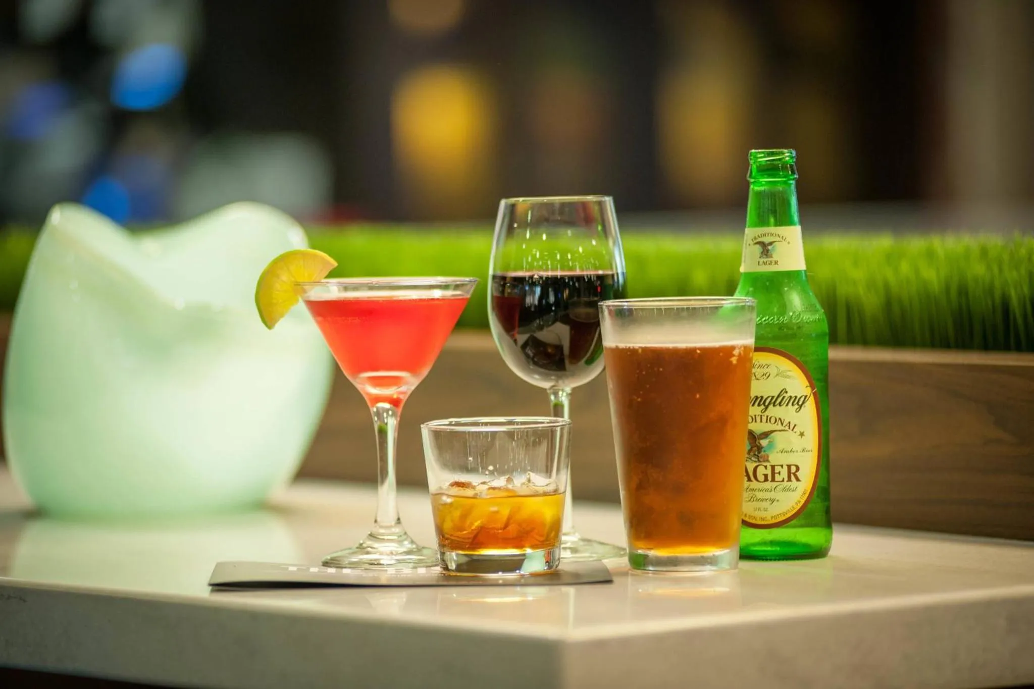 Des verres de boissons colorées sont présentés sur un comptoir.