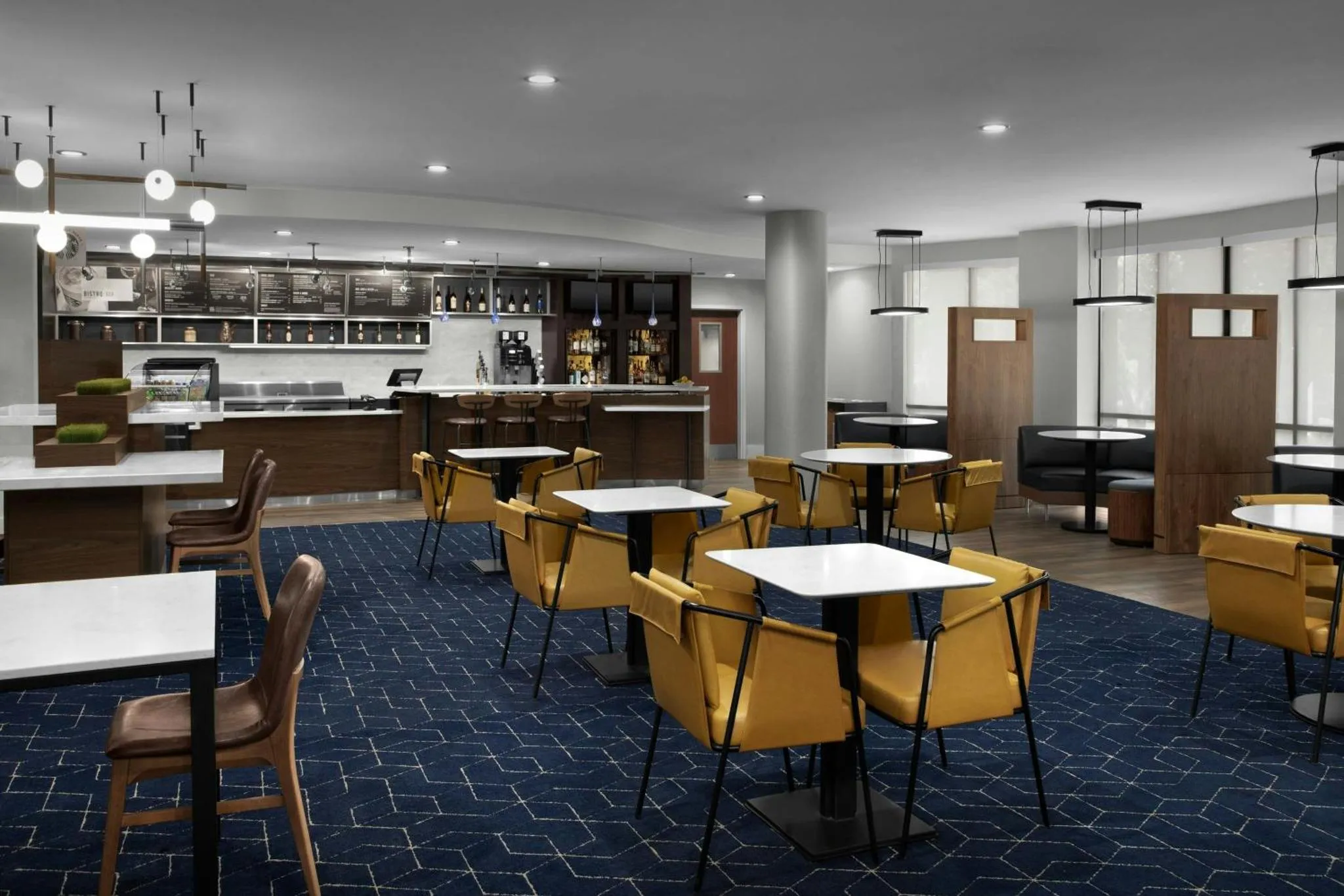Une salle lumineuse avec des tables et des chaises, un comptoir de service et des étagères remplies de produits.