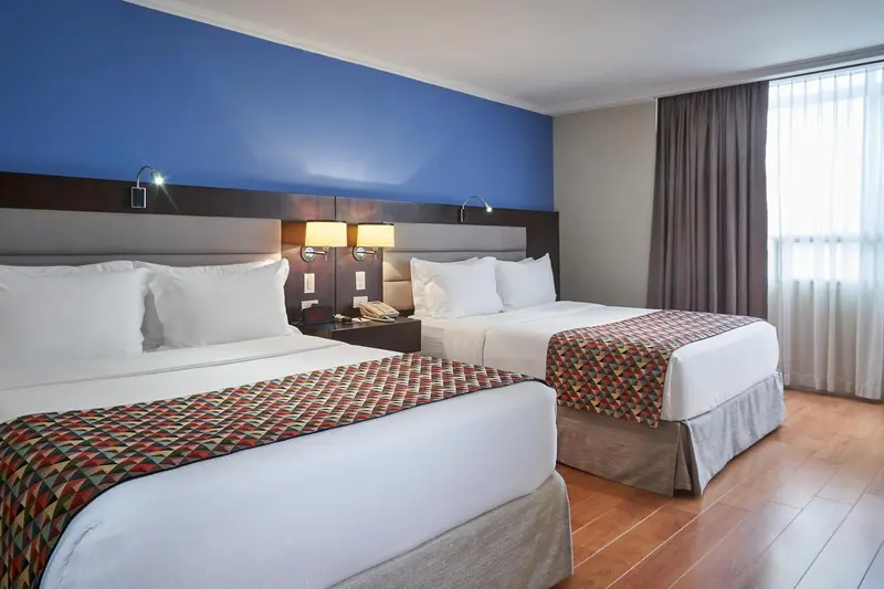 Chambre d'hôtel avec deux lits simples et une décoration sobre.