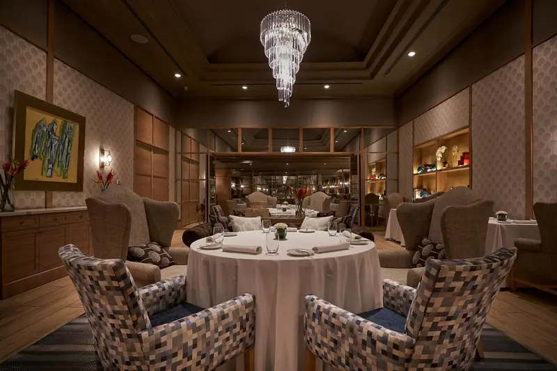 Une salle de restaurant élégante avec des tables dressées et un éclairage sophistiqué.