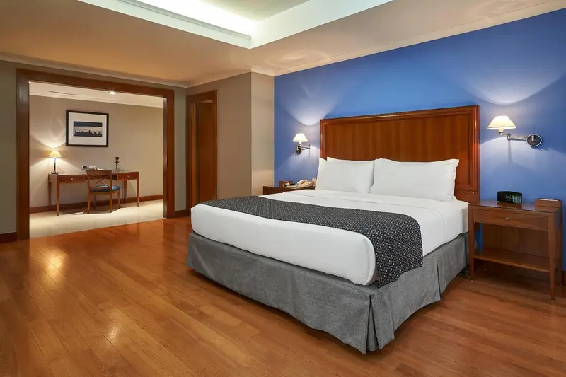 Une chambre d'hôtel lumineuse avec un grand lit et un bureau.