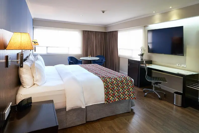 Une chambre d'hôtel lumineuse avec un lit double et un espace bureau.