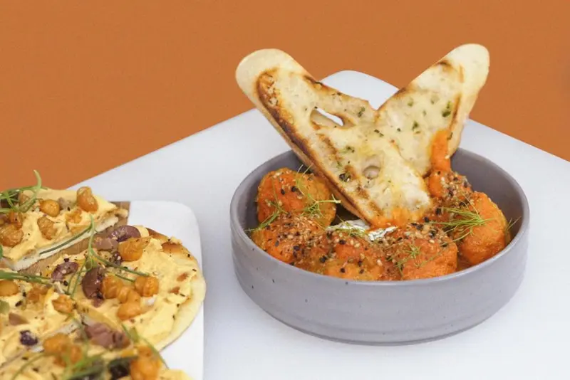 Assiette de pain grillé et de légumes orangés servis dans un bol.