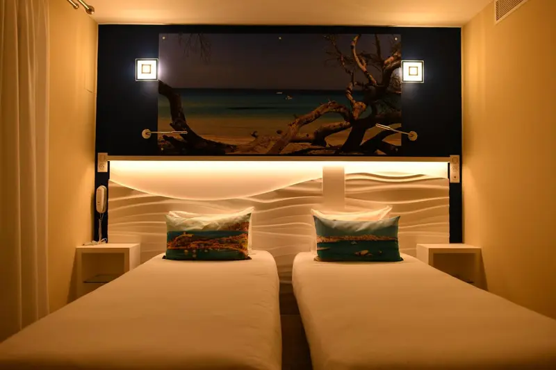 Deux lits simples dans une chambre aux murs clairs et à la décoration marine.