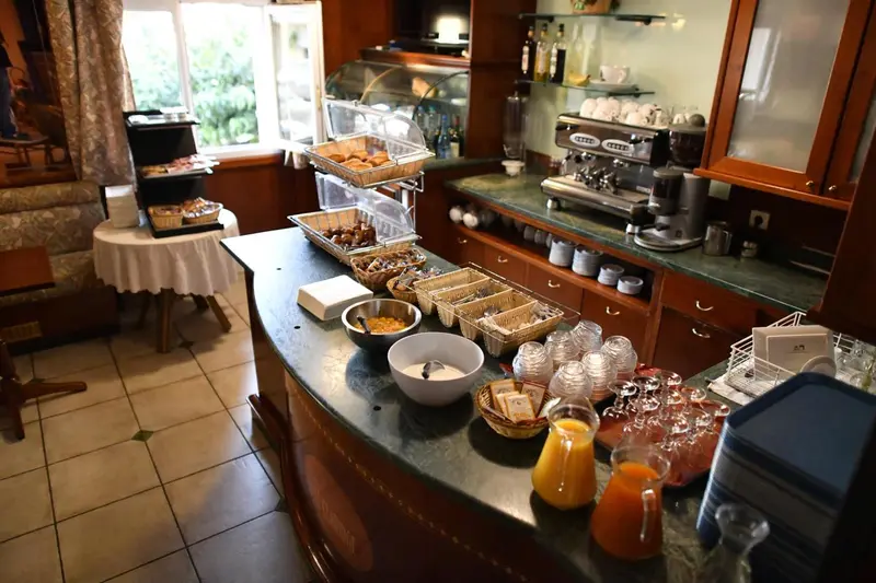 Un comptoir de buffet propose des viennoiseries, des fruits et des boissons.