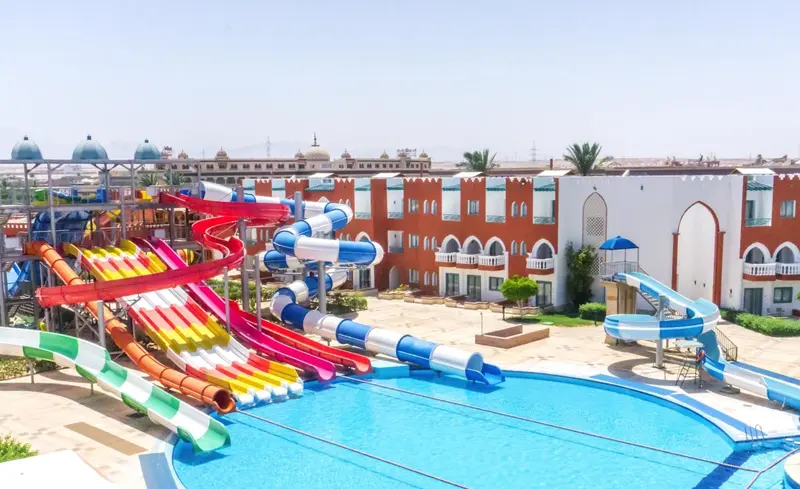 Une piscine avec des toboggans colorés dans un complexe hôtelier.