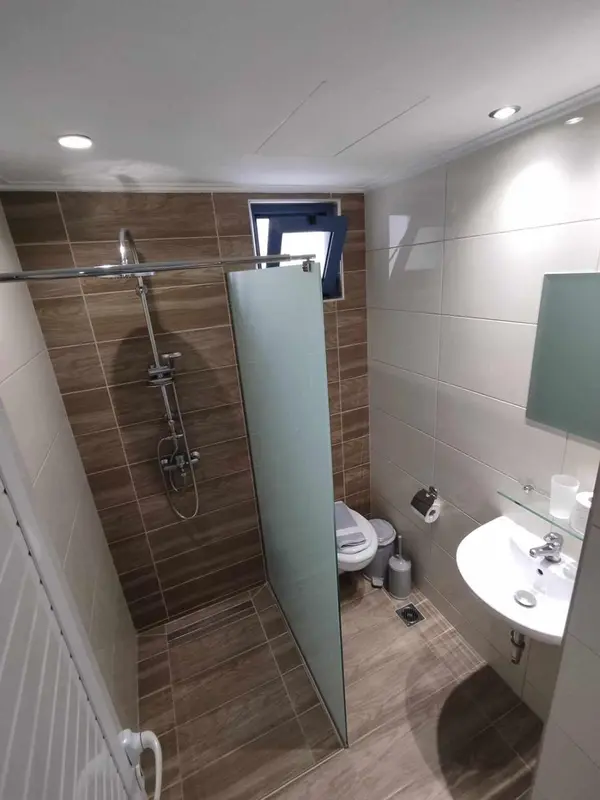 Une salle de bain carrelée avec douche et lavabo.