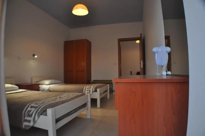 Une chambre lumineuse avec un lit et un meuble en bois.