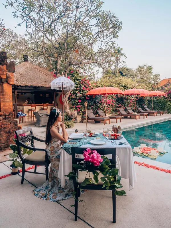 Une table dressée pour un repas en extérieur près d'une piscine.